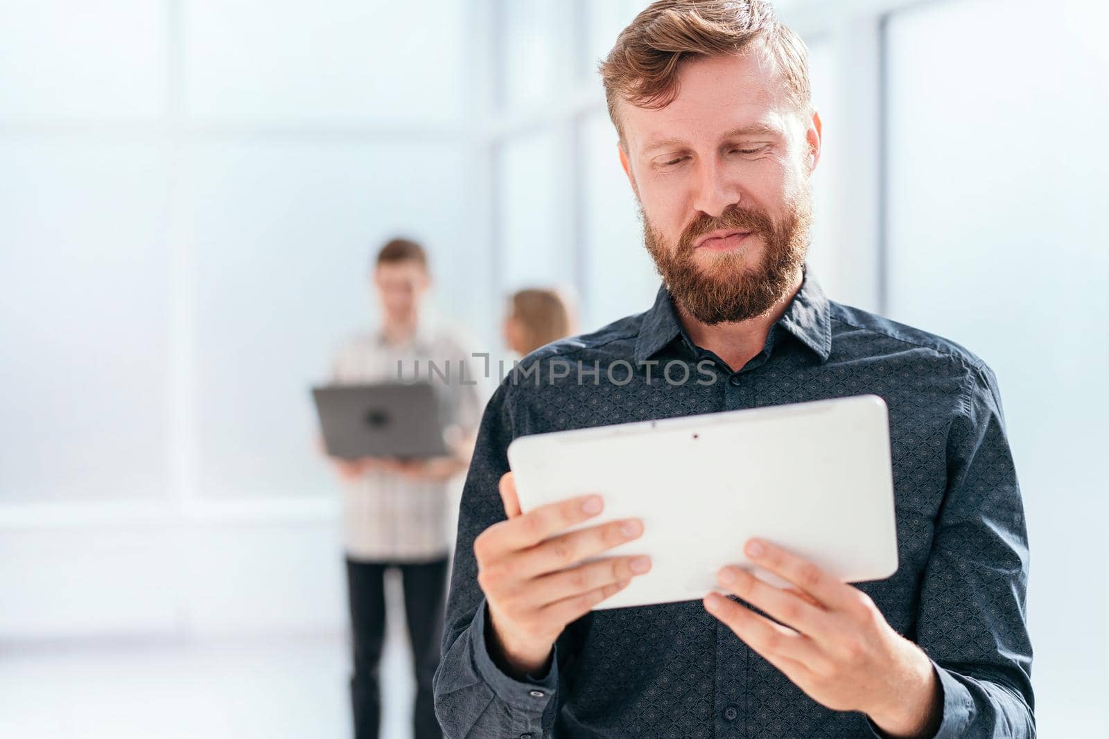 serious businessman reading message on digital tablet. photo with copy space