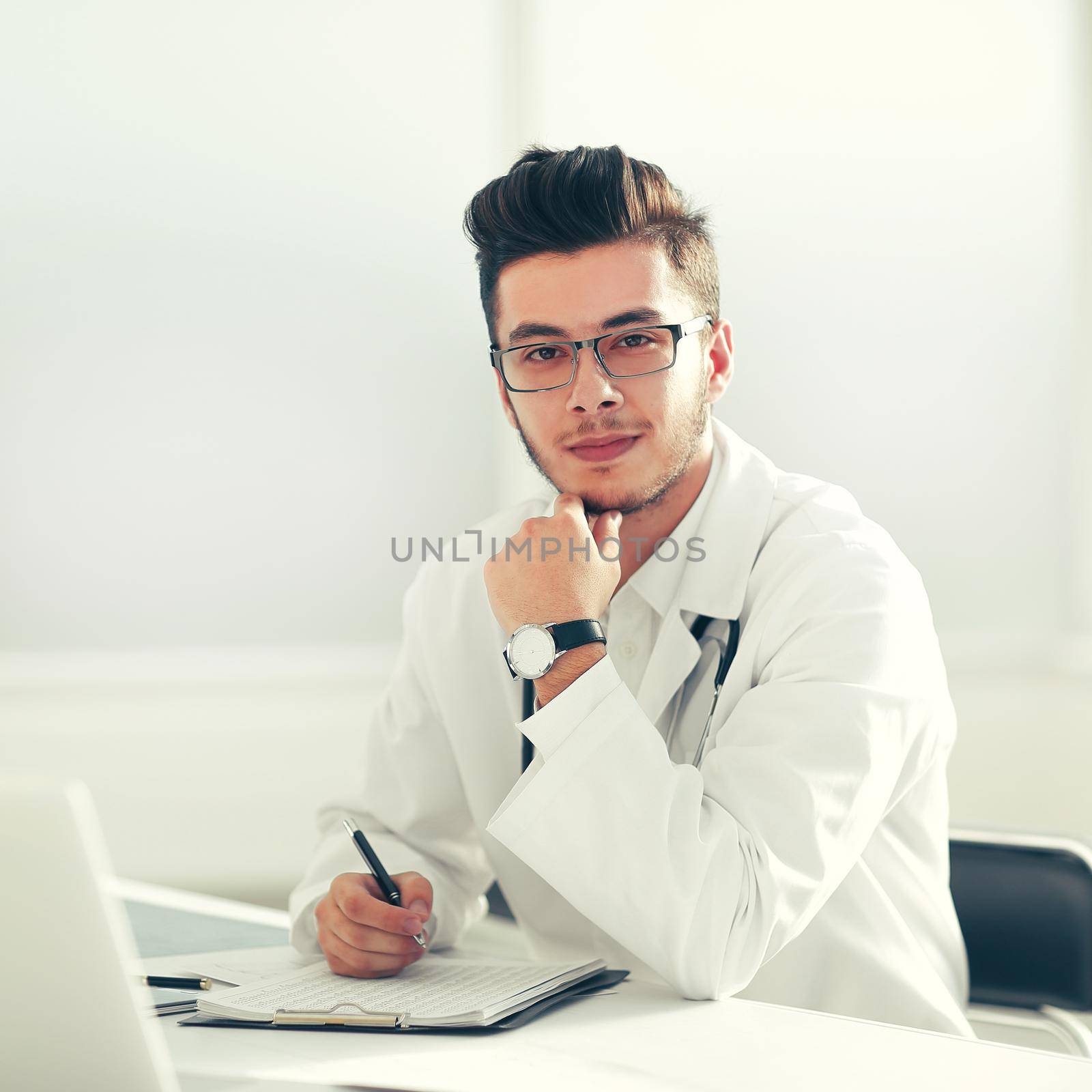 doctor therapist sitting at a table in his office by SmartPhotoLab