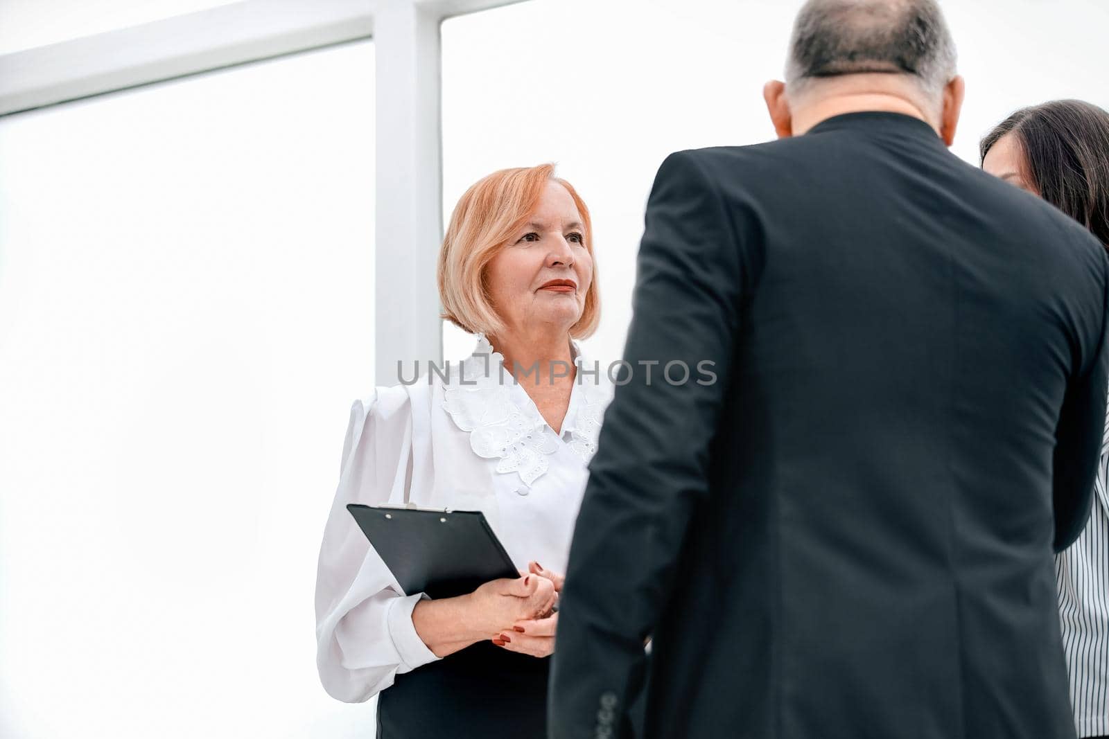 close up. business colleagues discussing something standing in the office lobby. office weekdays