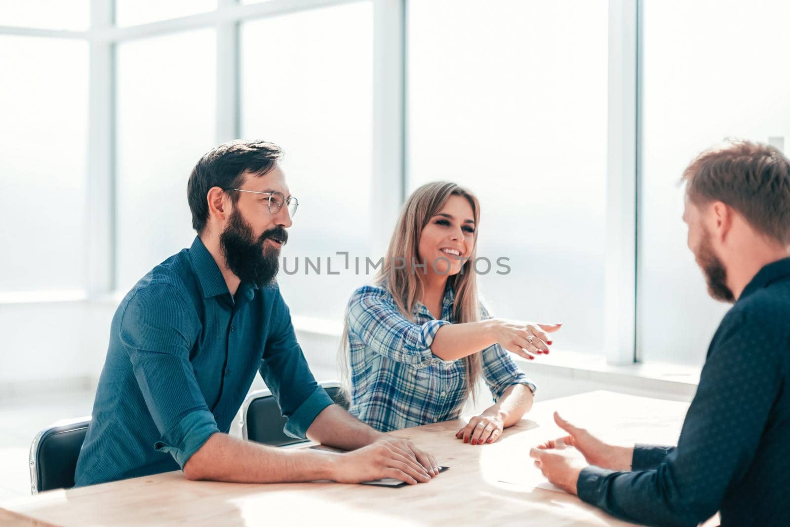 group of successful young people sitting at the negotiating table. the concept of employment