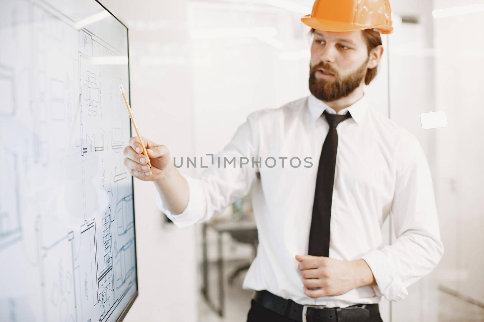 Architect and engineer. Man shows plan of building. TV screen.