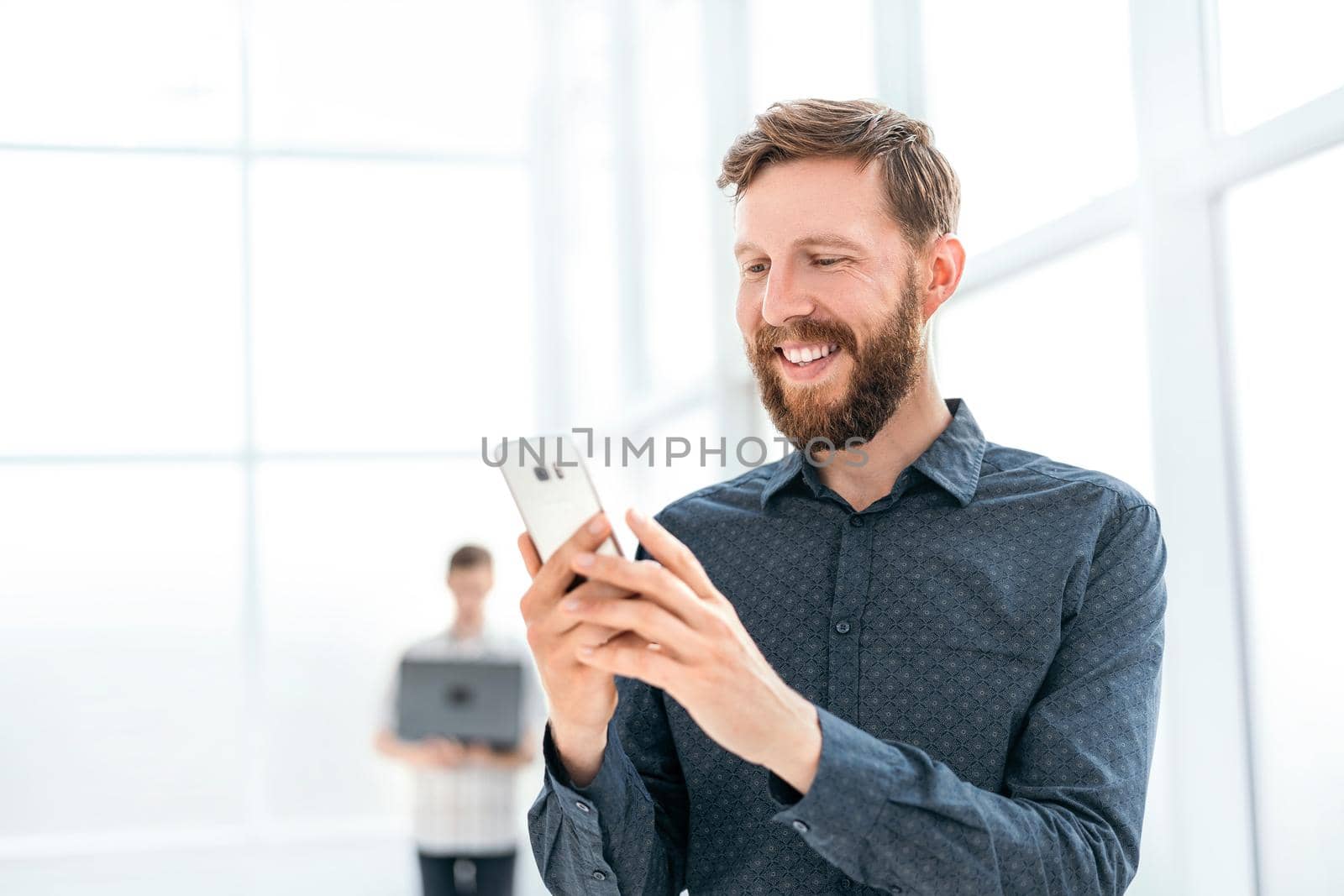 handsome businessman choosing a contact number in his smartphone. photo with copy space