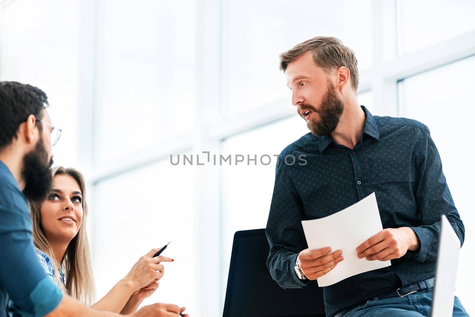 young businessman reading a document sitting on an office table. office weekdays