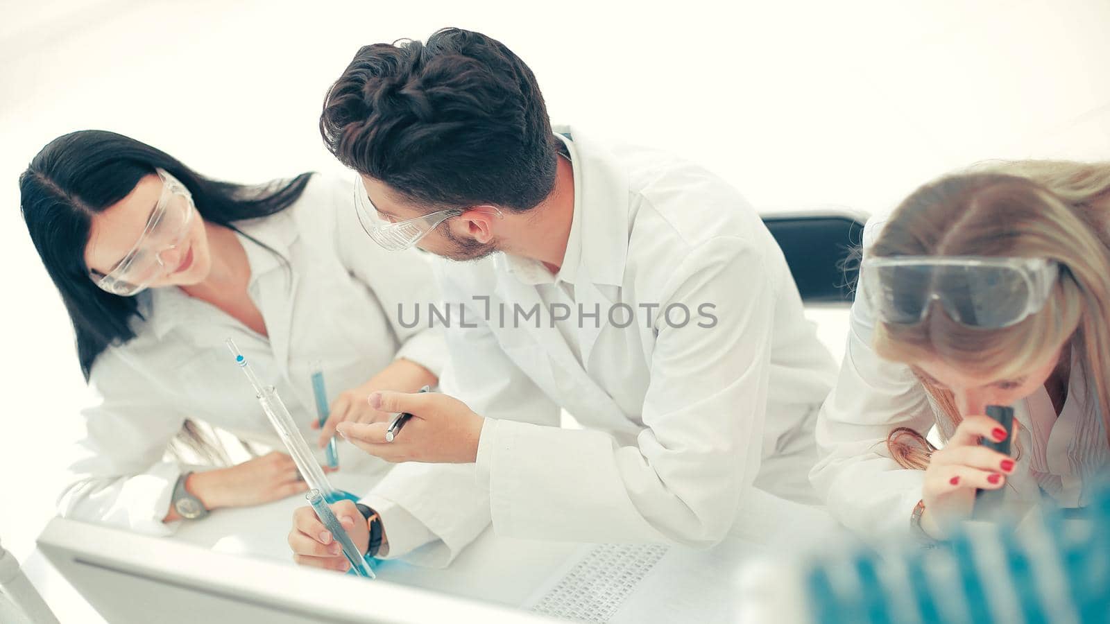 close up. a group of scientists conduct research and make entries in the journal. science and health