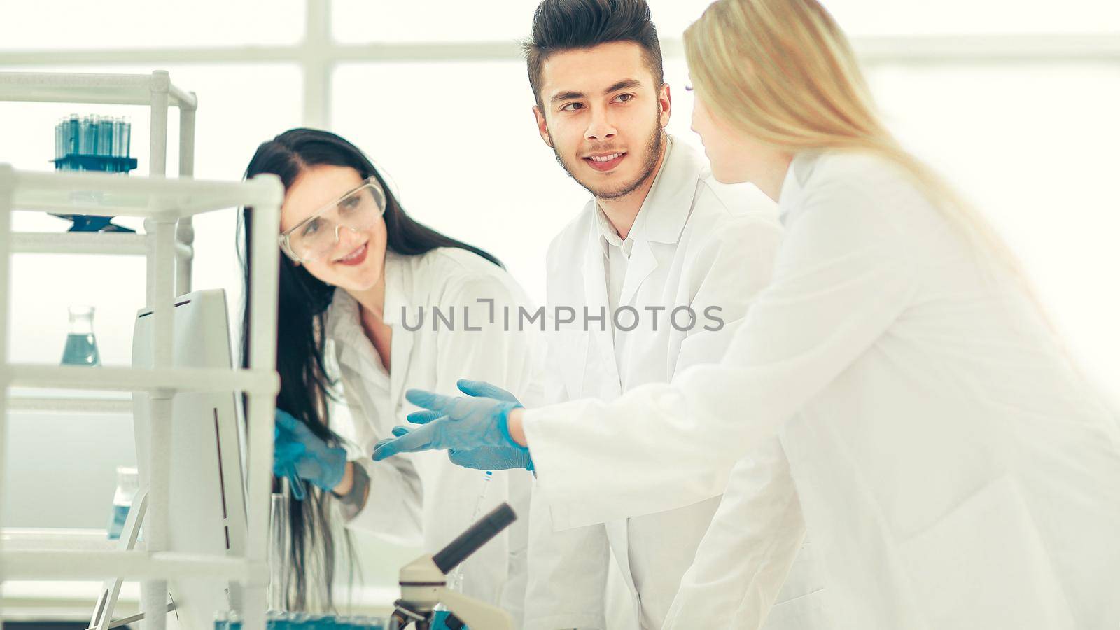 group of young scientist discussing something in their lab by SmartPhotoLab