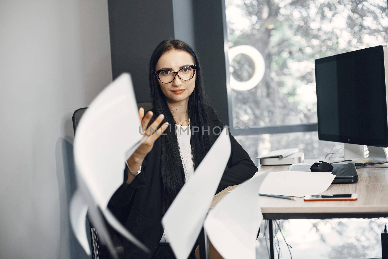 Lady with glasses. Manager is sitting at the computer. Businesswoman works in her office.