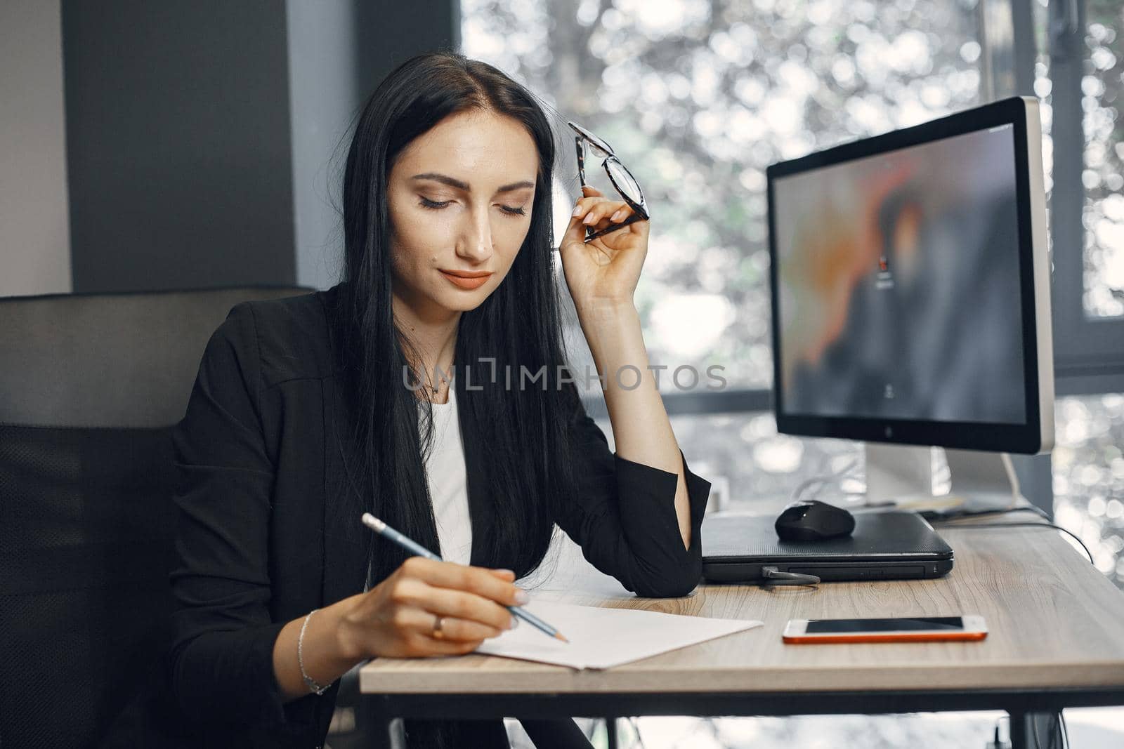 Lady with glasses. Manager is sitting at the computer. Businesswoman works in her office.