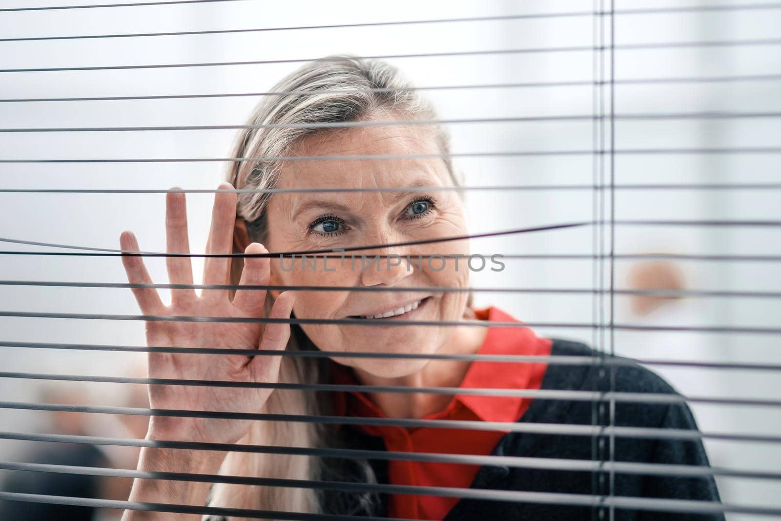 close up. senior business woman looking through office blinds
