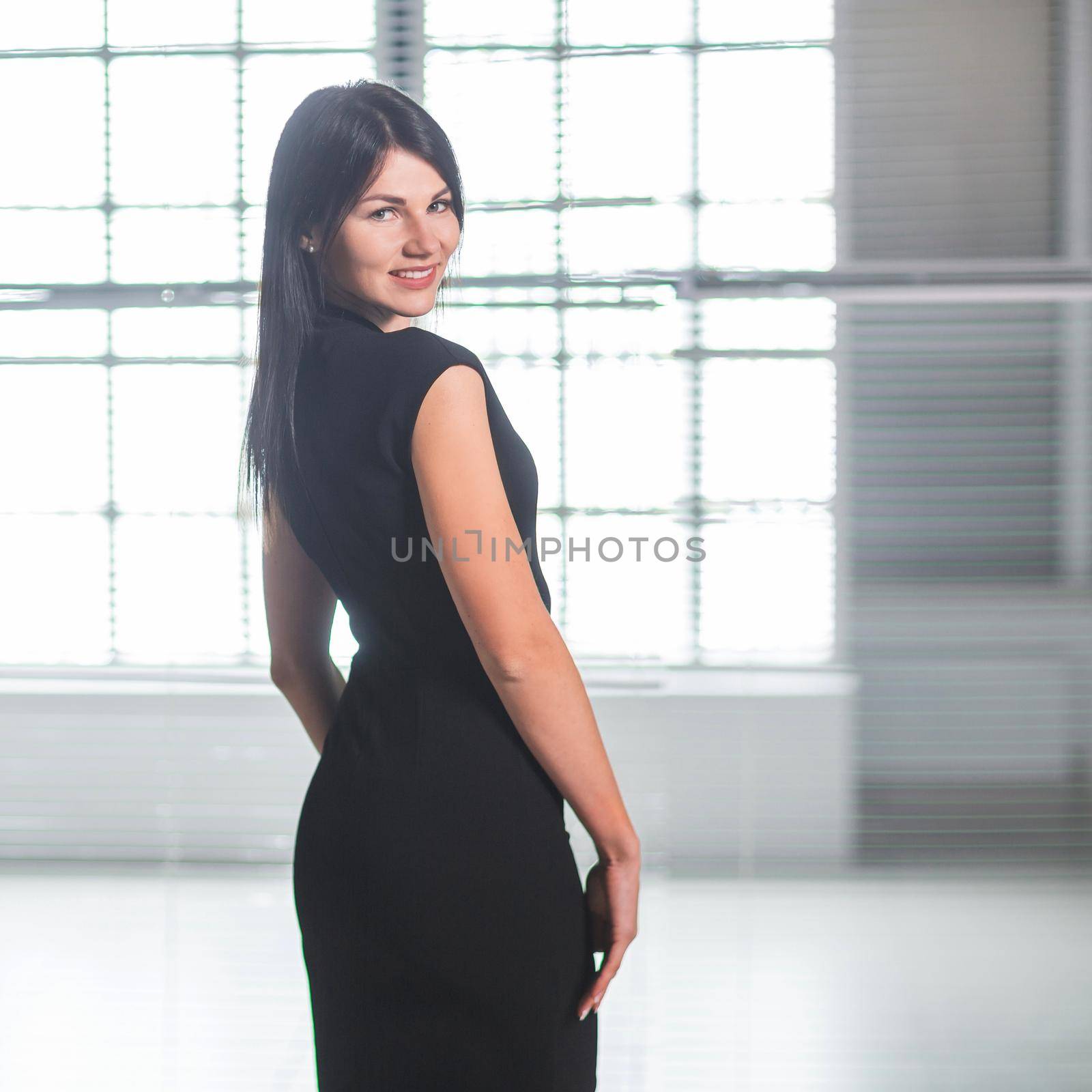 happy young businesswoman standing in a spacious office by SmartPhotoLab