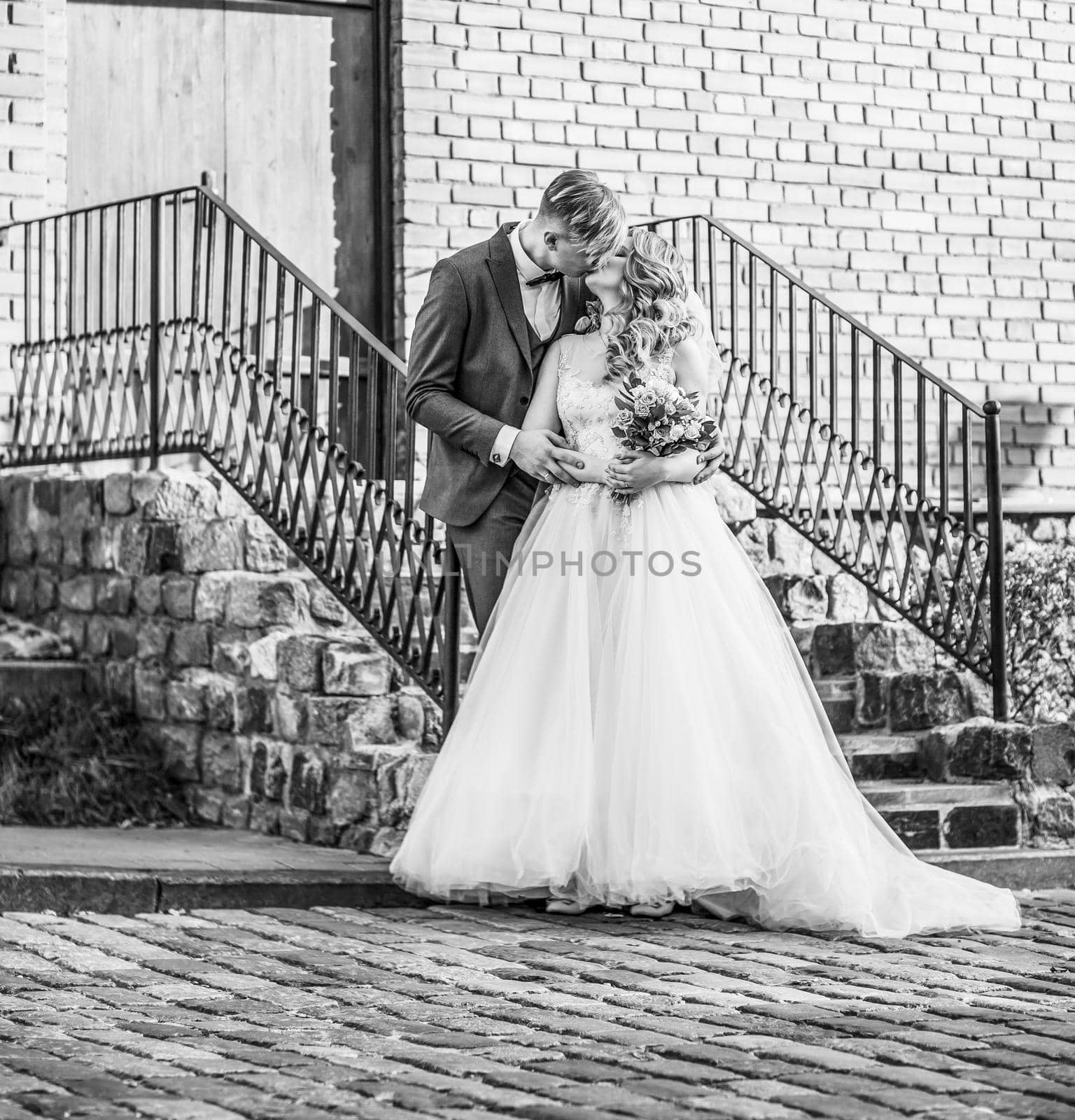 bride and groom kiss, standing on the porch of the house. holidays and events