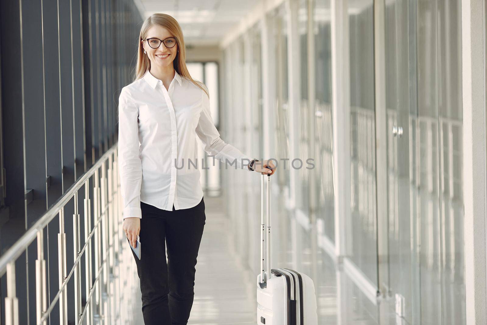 Woman at the airport. Girl with suitcase. Lady in a white shirt.