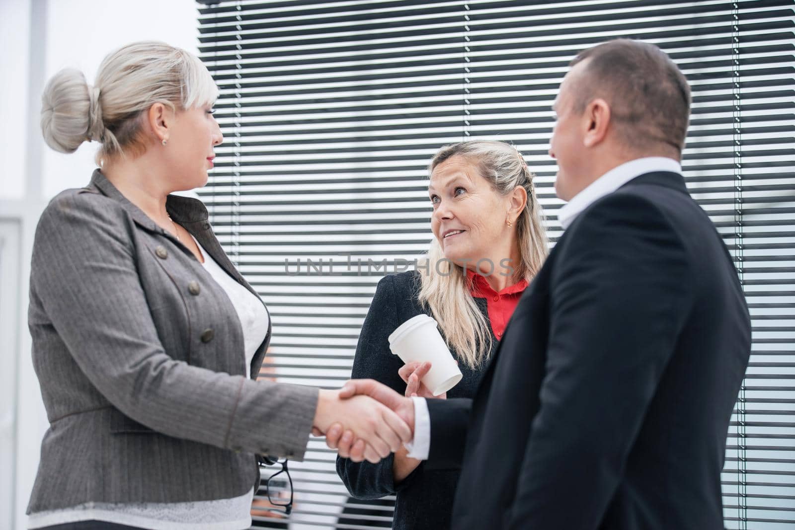 close up. business partners shaking hands at an office meeting. business concept