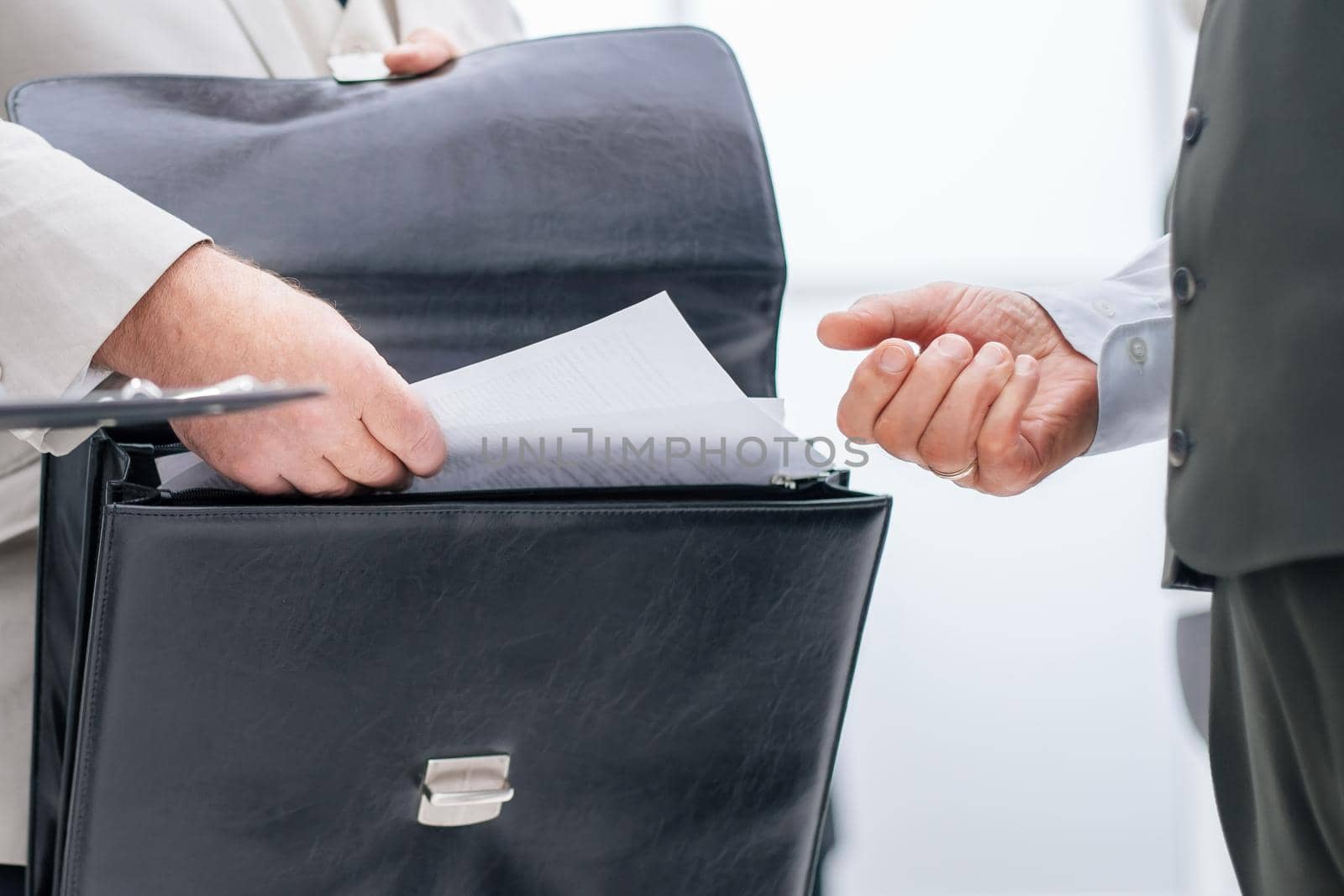 close up. businessman taking out of his briefcase business documents. business concept