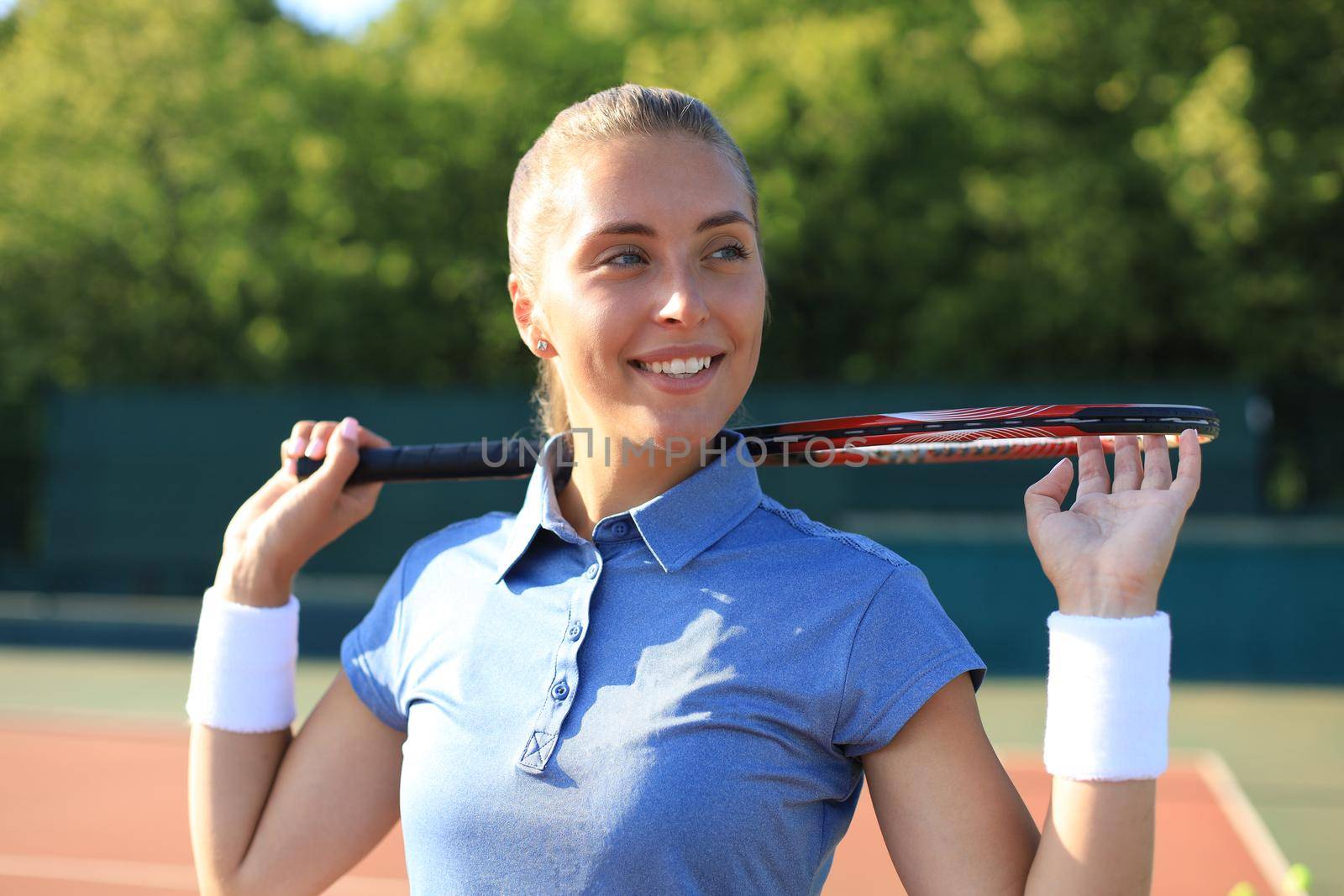 Pretty sportswoman with racquet at the tennis court. Healthy lifestyle