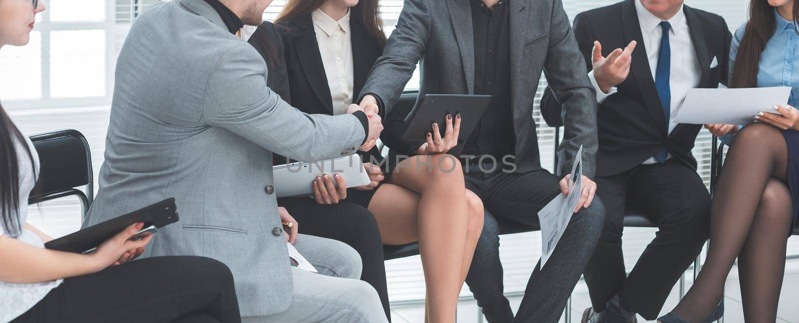 business colleagues shaking hands at an office meeting. by SmartPhotoLab