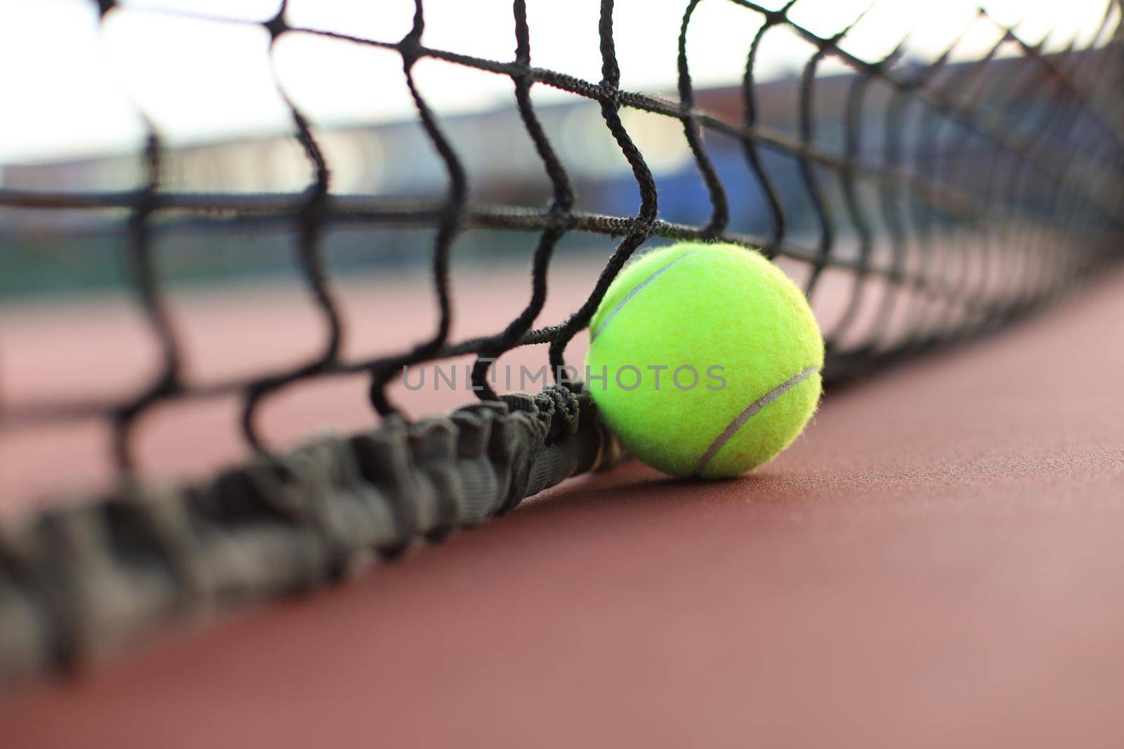 Bright greenish yellow tennis ball on clay court. by tsyhun