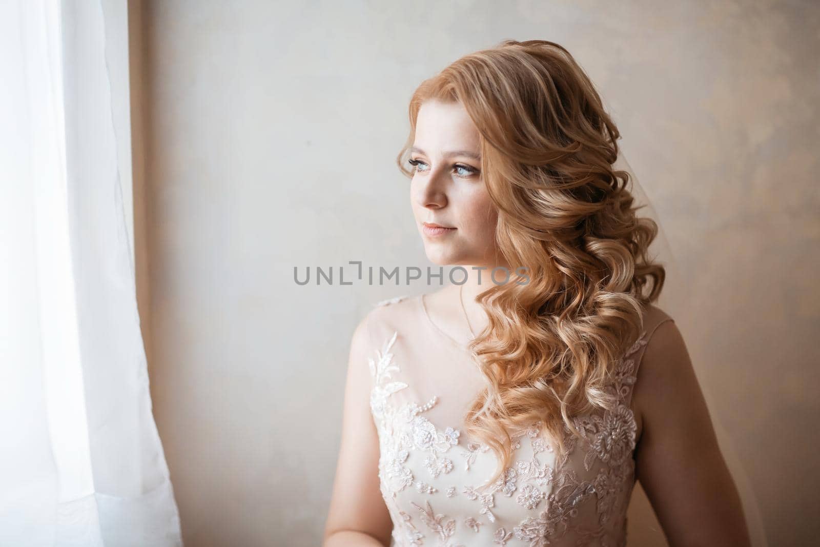 close up. young woman in wedding dress standing near the window. holidays and events