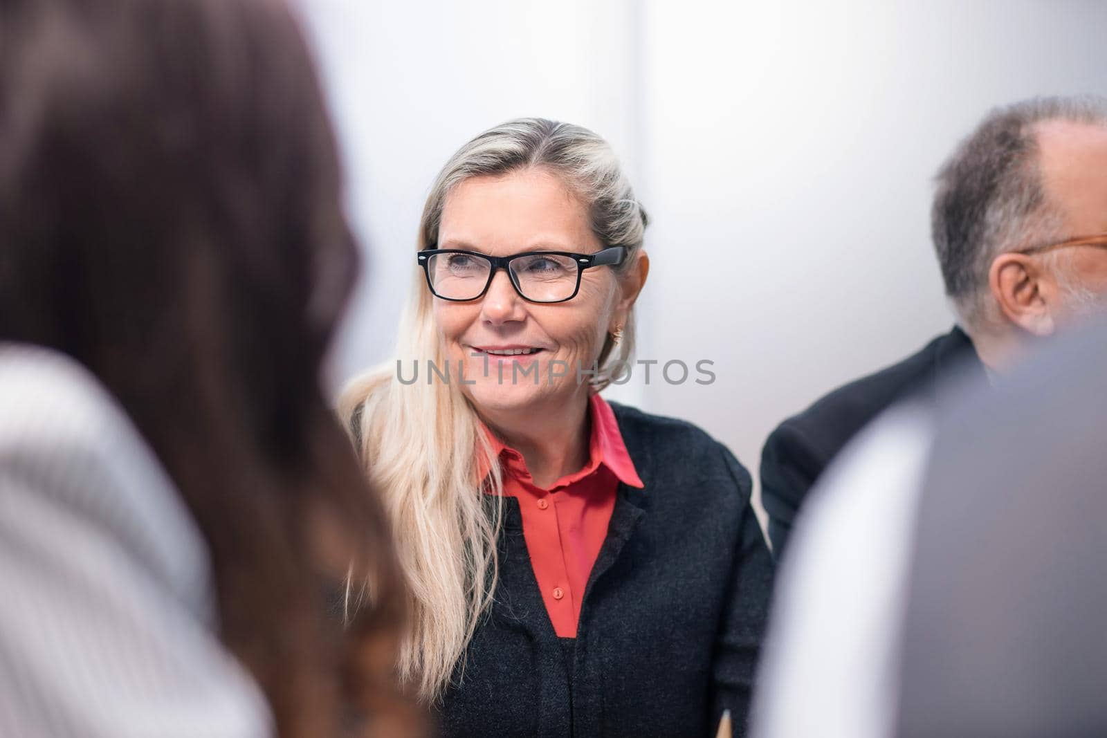 close up. senior businesswoman sitting among her colleagues . business people