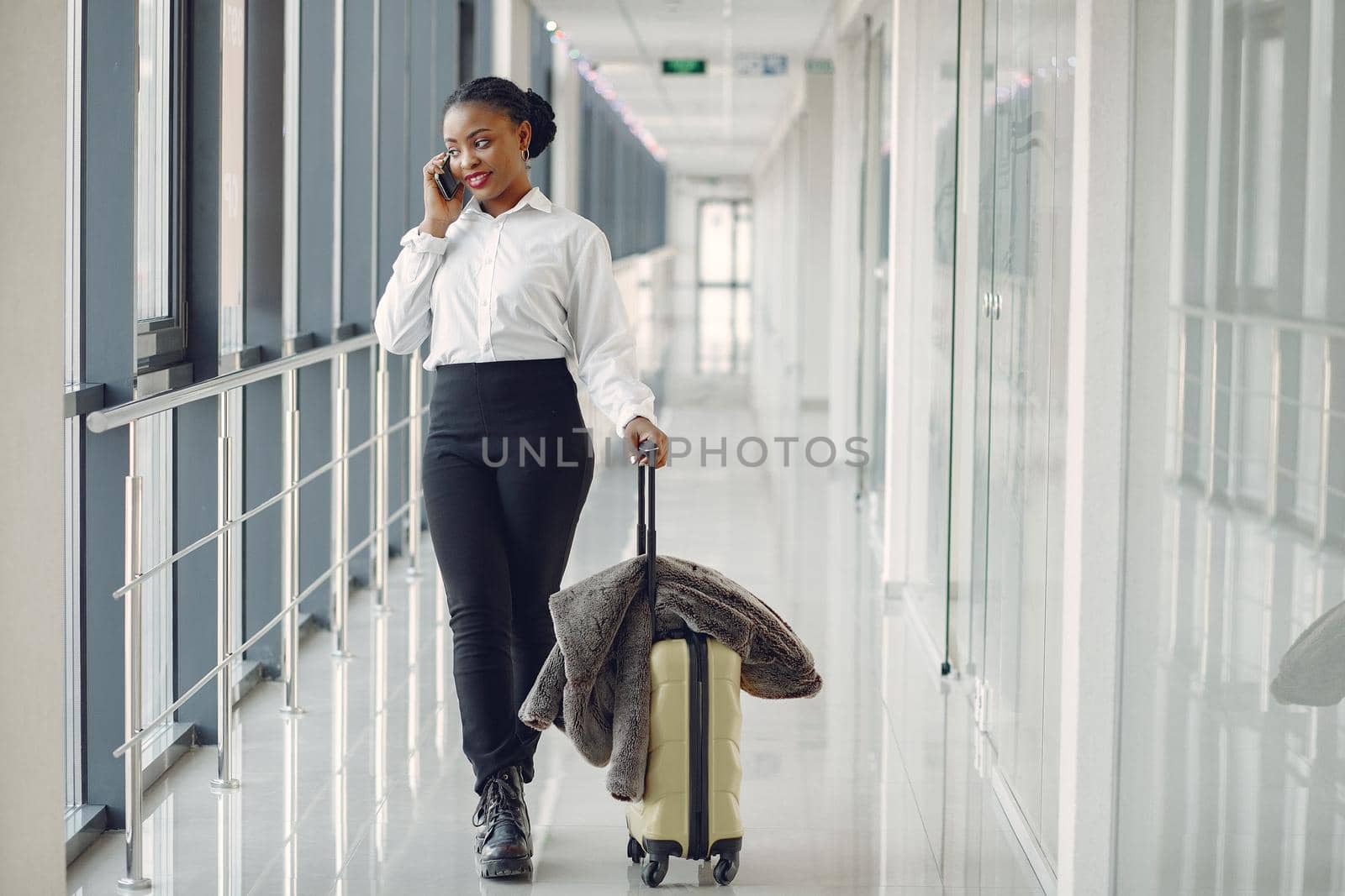 Black woman with suitcase at the airport by prostooleh