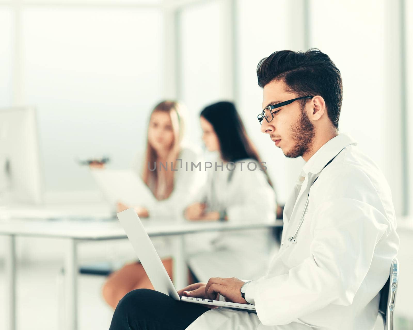 doctor works on a laptop in the hospital room .photo with copy space