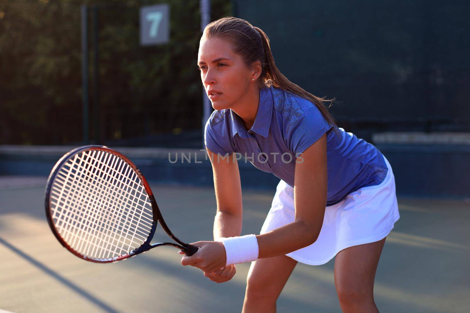Pretty sportswoman with racquet at the tennis court. Healthy lifestyle. by tsyhun