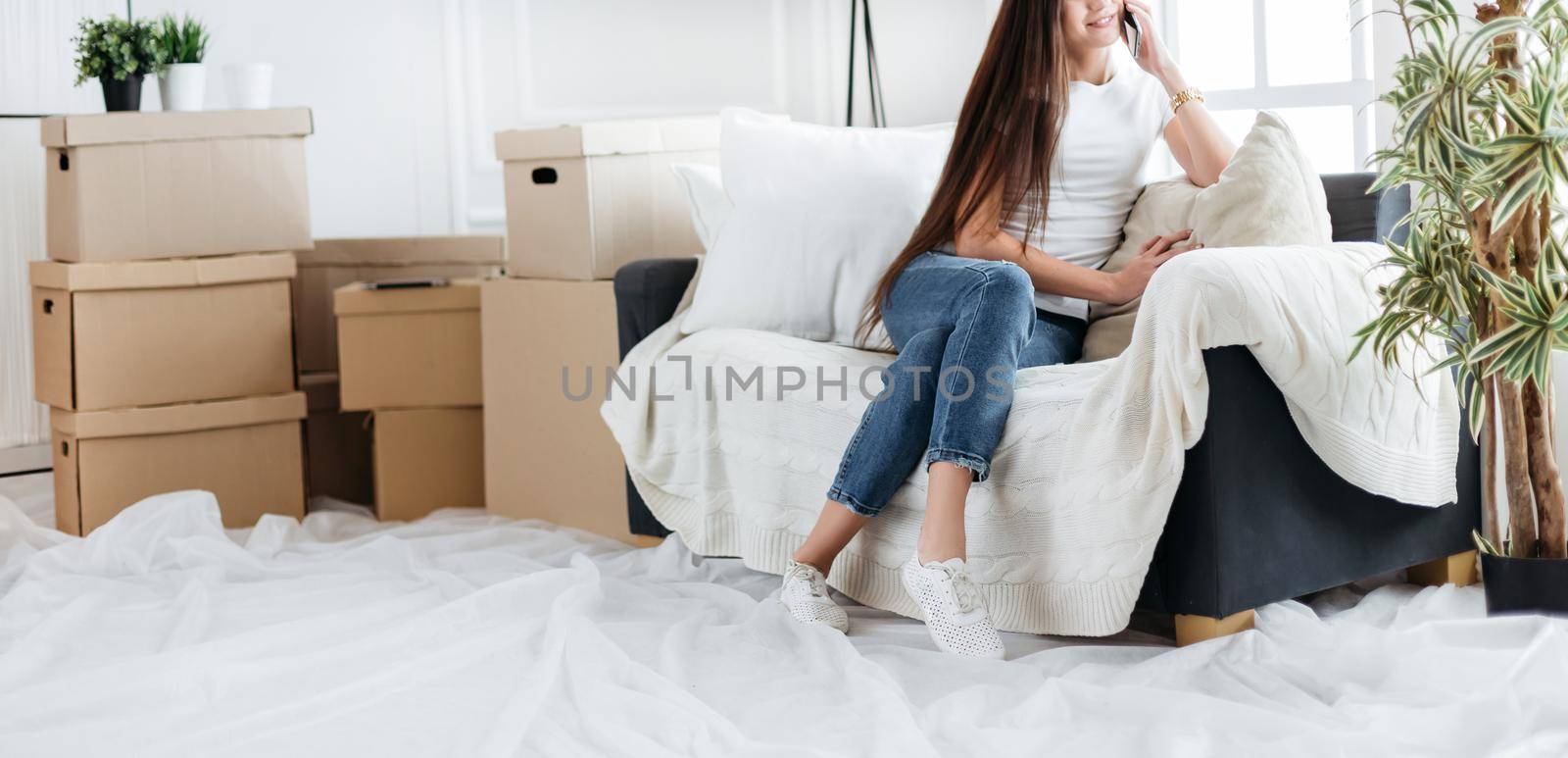 young woman making an order on her smartphone in a new apartment. photo with copy-space