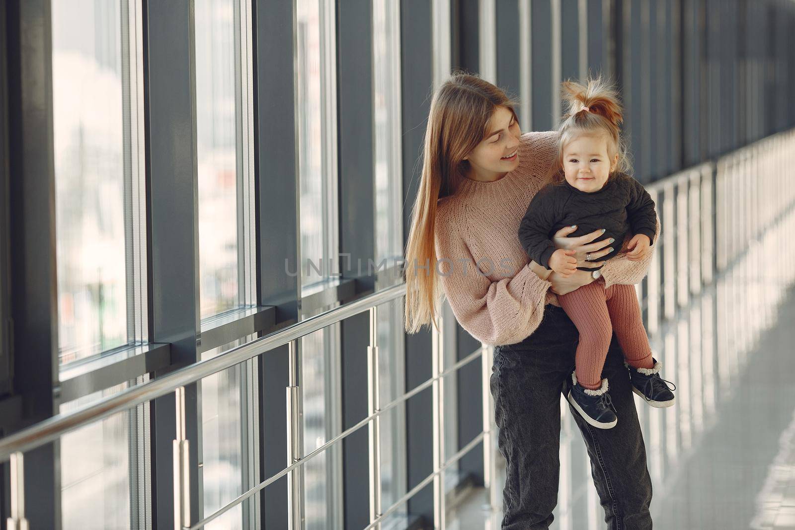 Mother with daughter. Family in hall. Woman in a pink sweater.