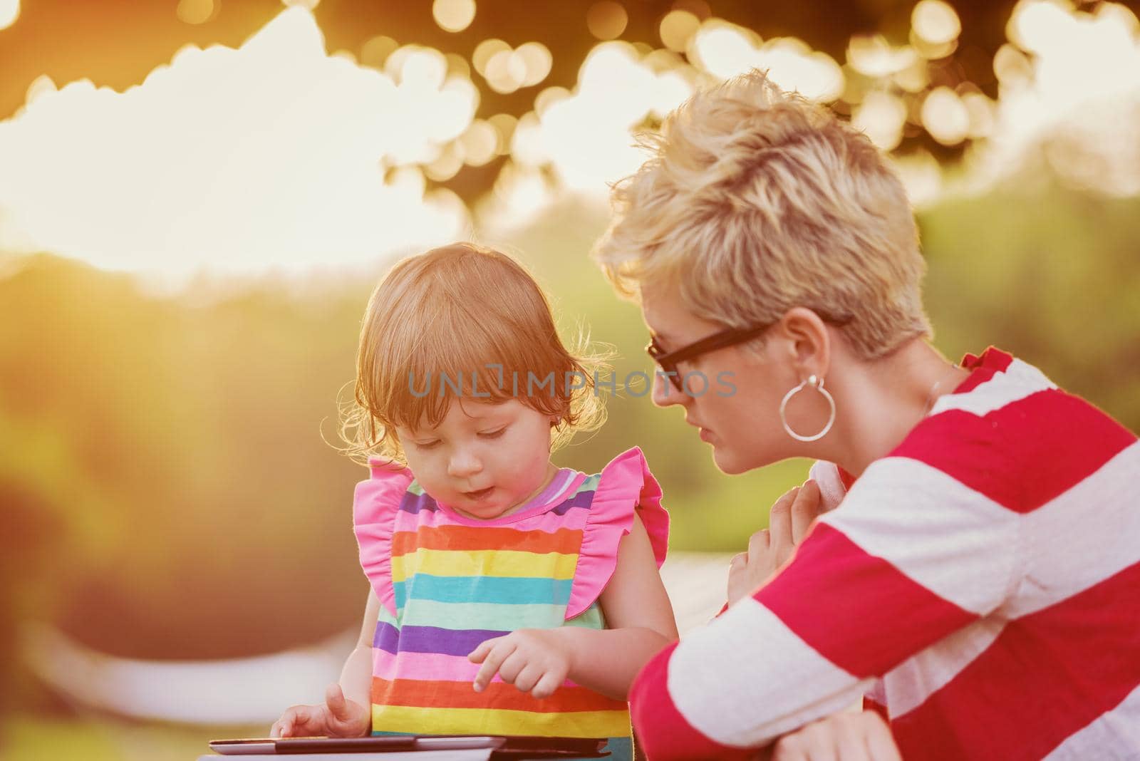 mom and her little daughter using tablet computer by dotshock