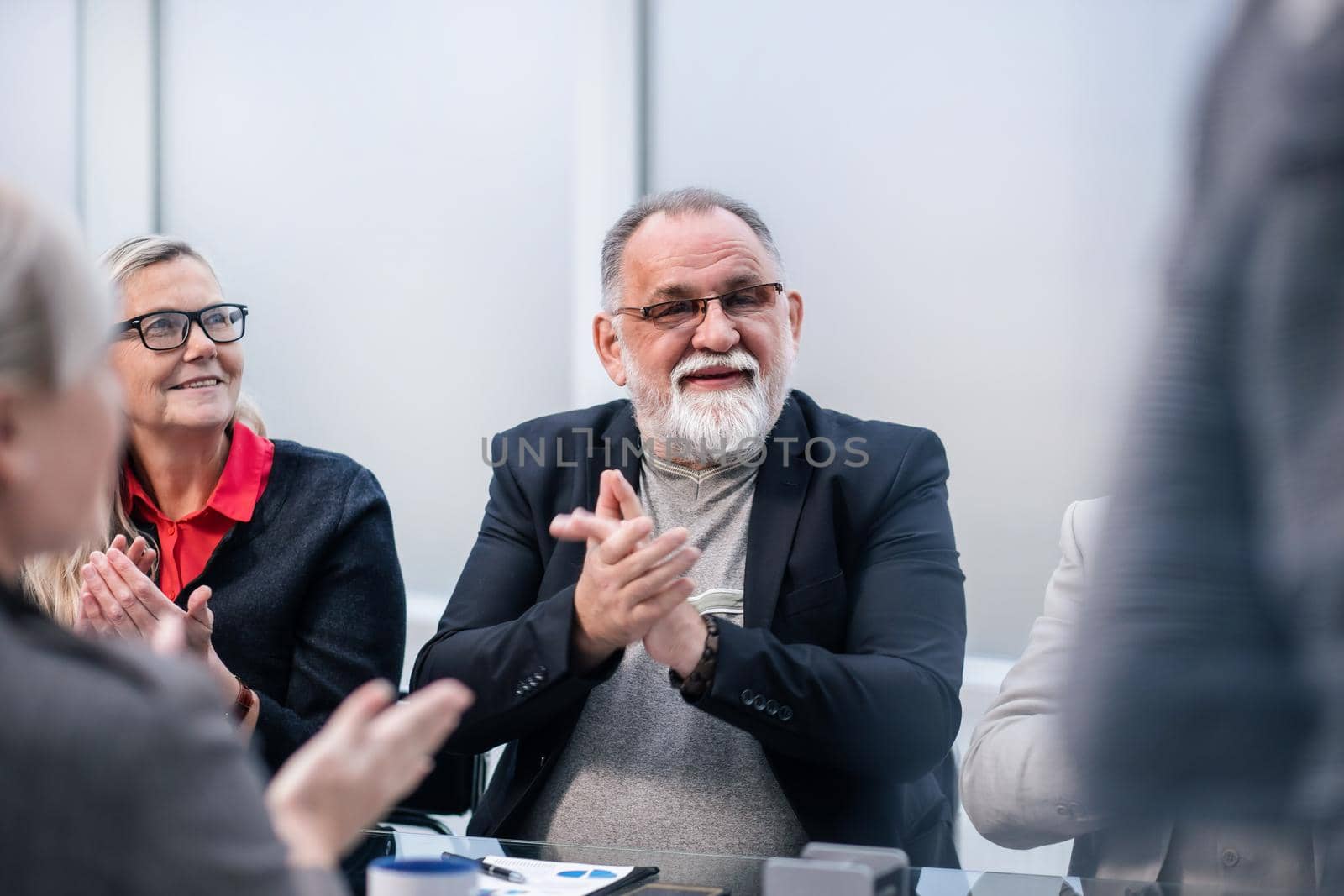 close up. smiling boss applauds during a work meeting. business concept