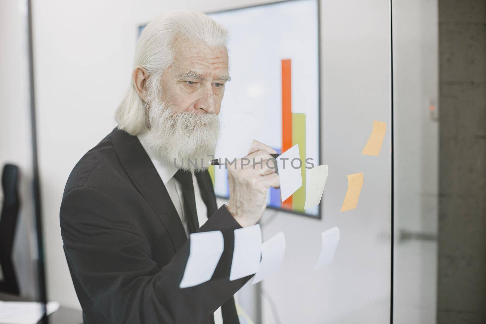 Close up portrait of old-fashioned man. Elegant man at the office. Senior with a documents.