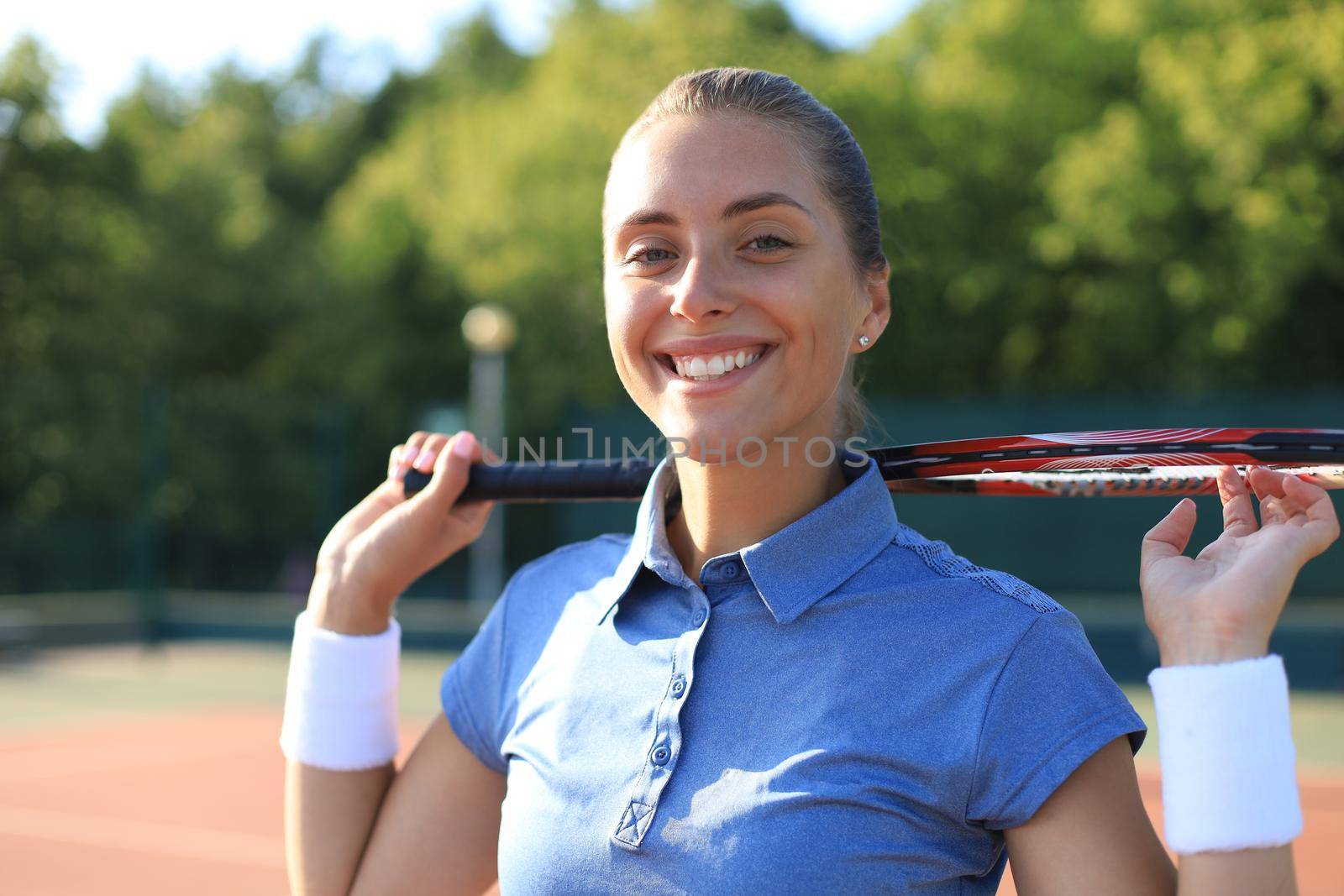 Pretty sportswoman with racquet at the tennis court. Healthy lifestyle. by tsyhun