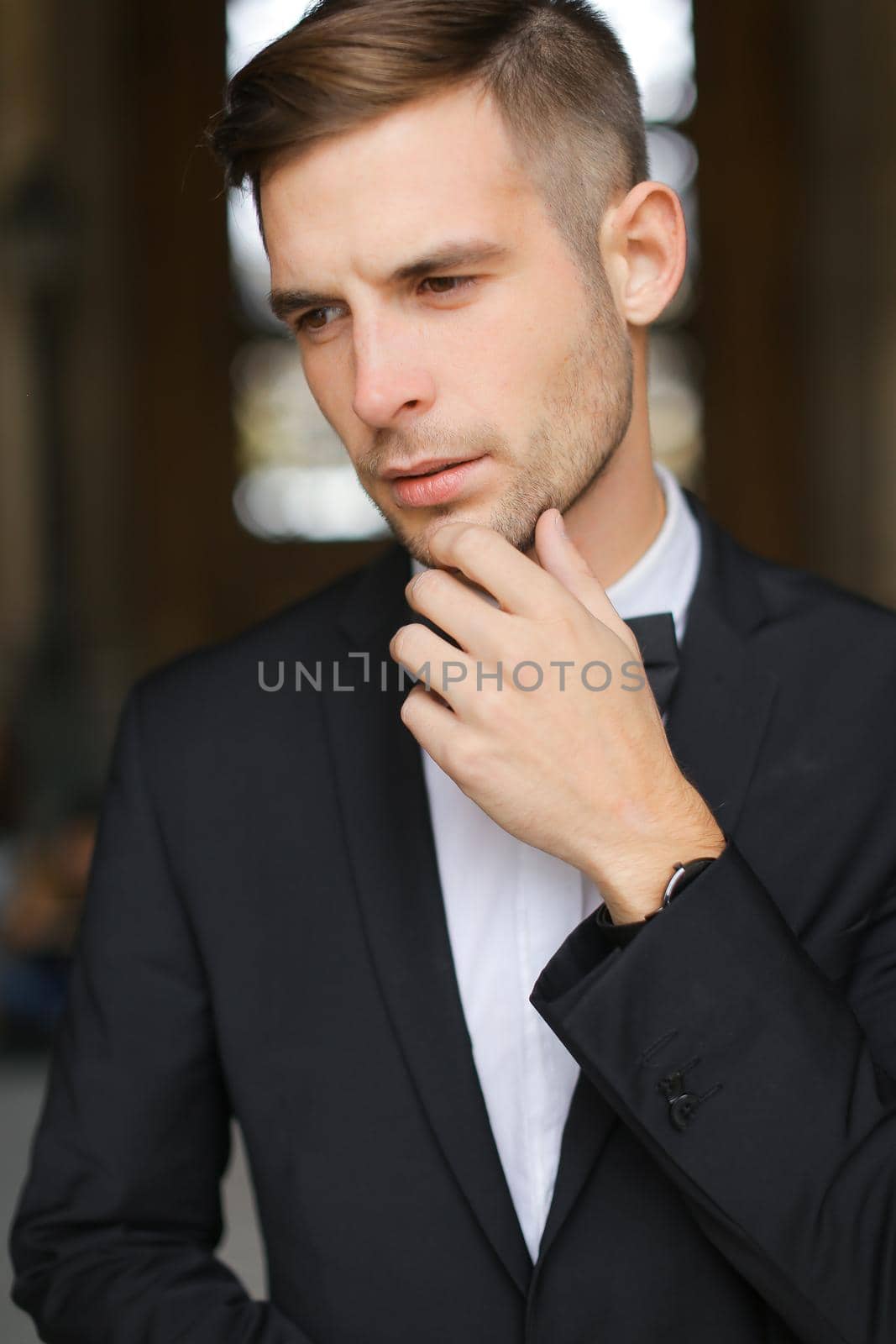 Portrait of young man wearing black suit with bow tie. by sisterspro