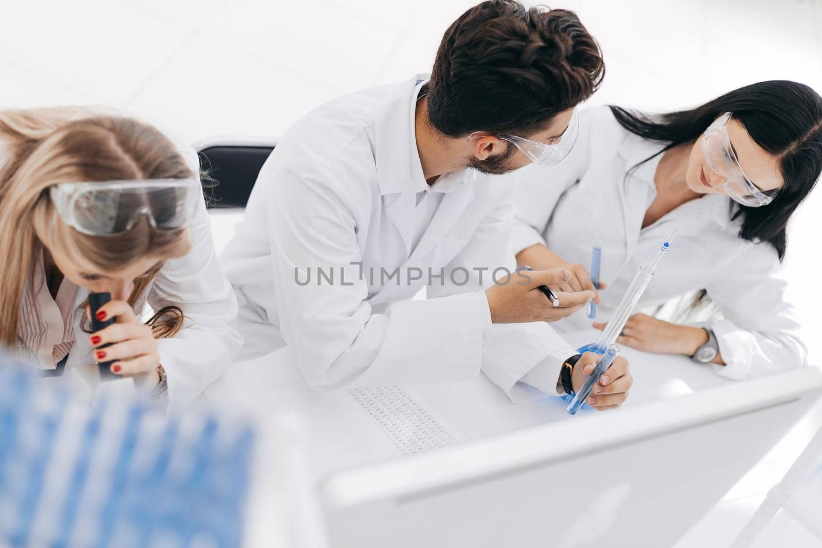 close up. a group of scientists conduct research and make entries in the journal. science and health