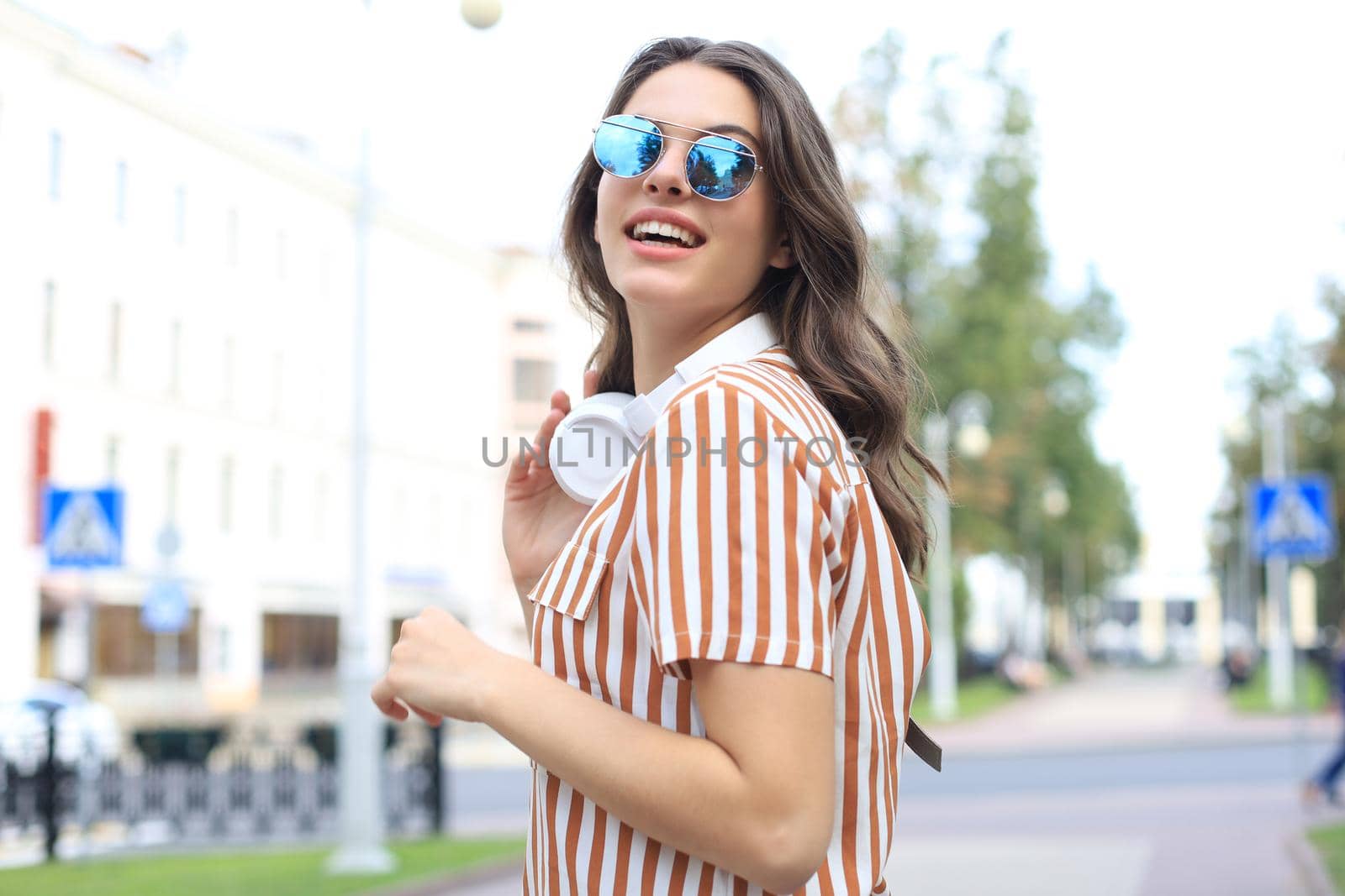 Smiling happy young beautiful woman walking outdoors. by tsyhun