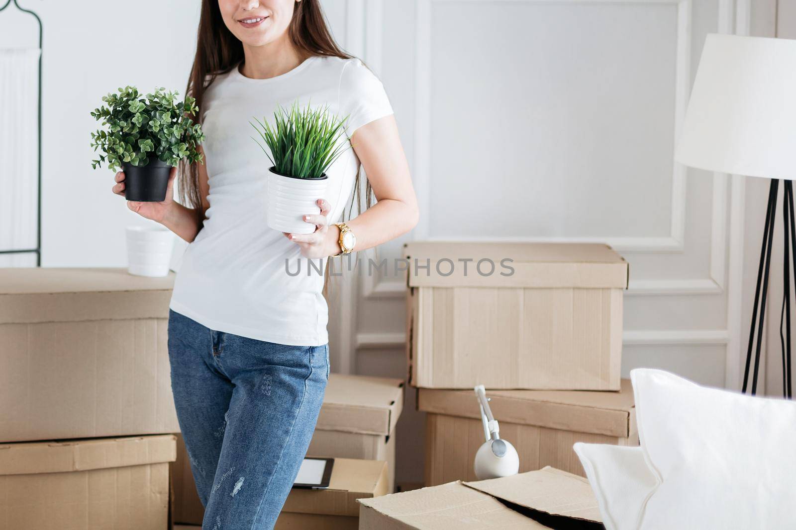 close up. young woman arranging flower pots in new apartment