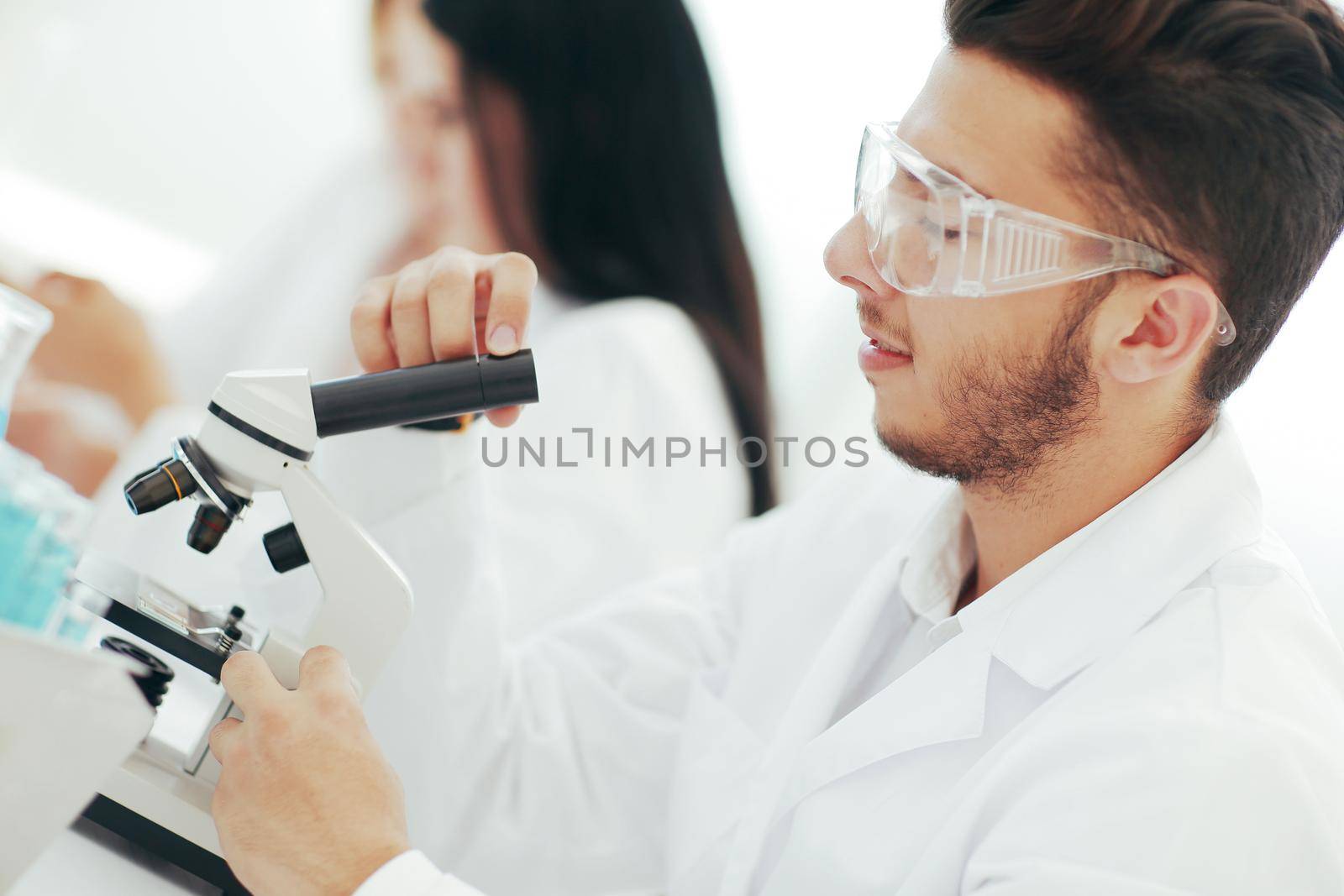 close up.man scientist looking through a microscope by SmartPhotoLab