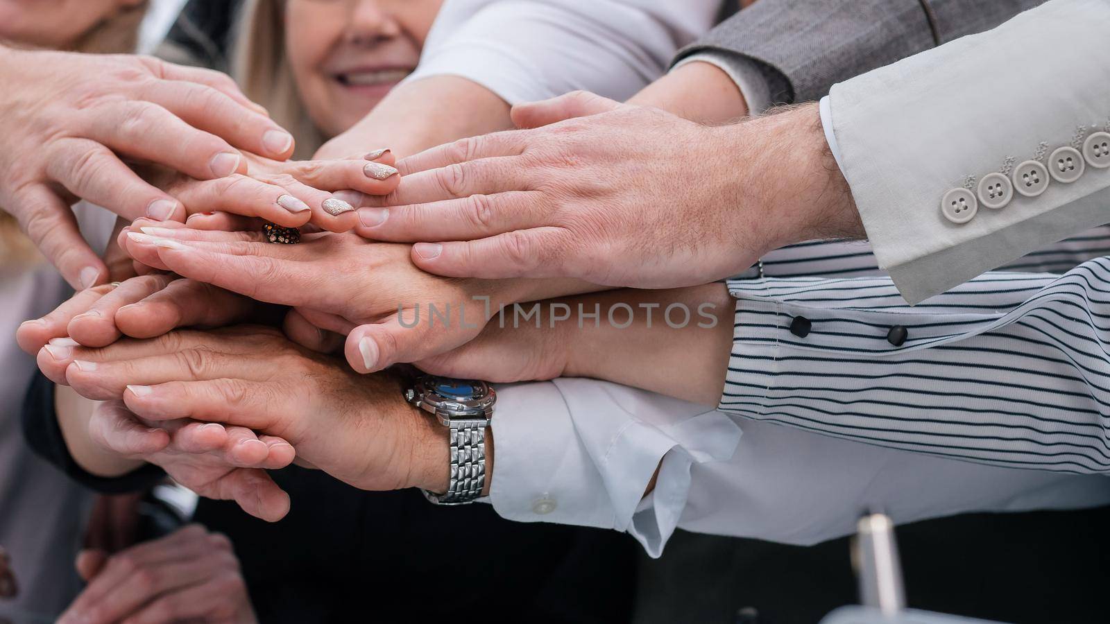 close up. a group of diverse employees joining their palms together. the concept of teamwork