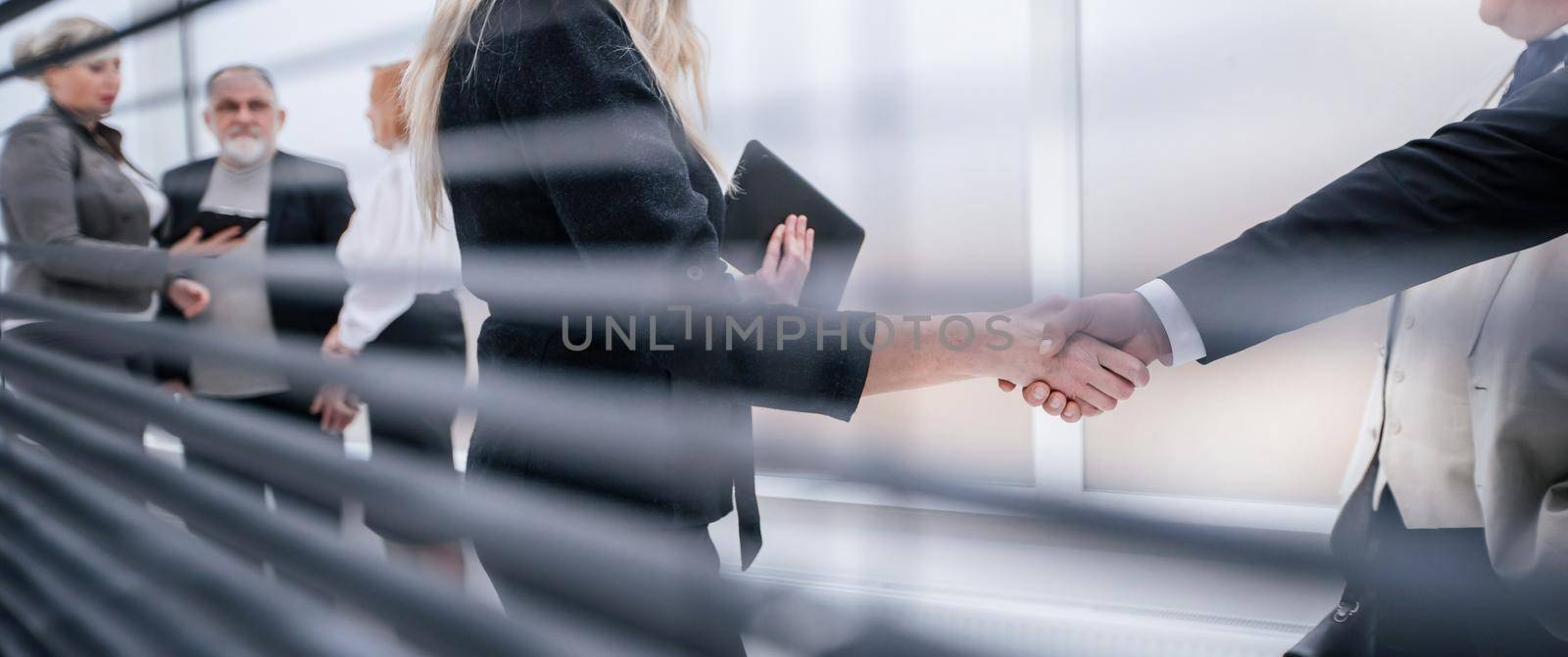 through-blinds. confident businesswoman shaking hands with her business partner. the concept of cooperation