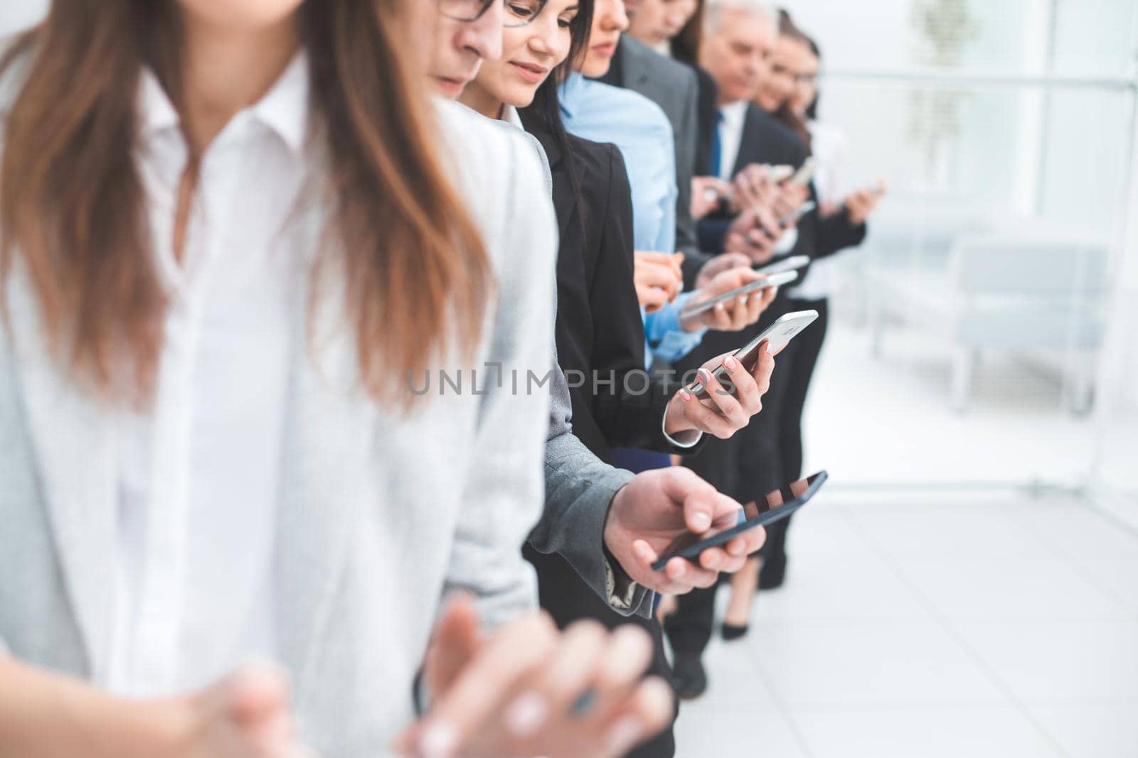 close up. a group of young business people looking at their smartphone screens