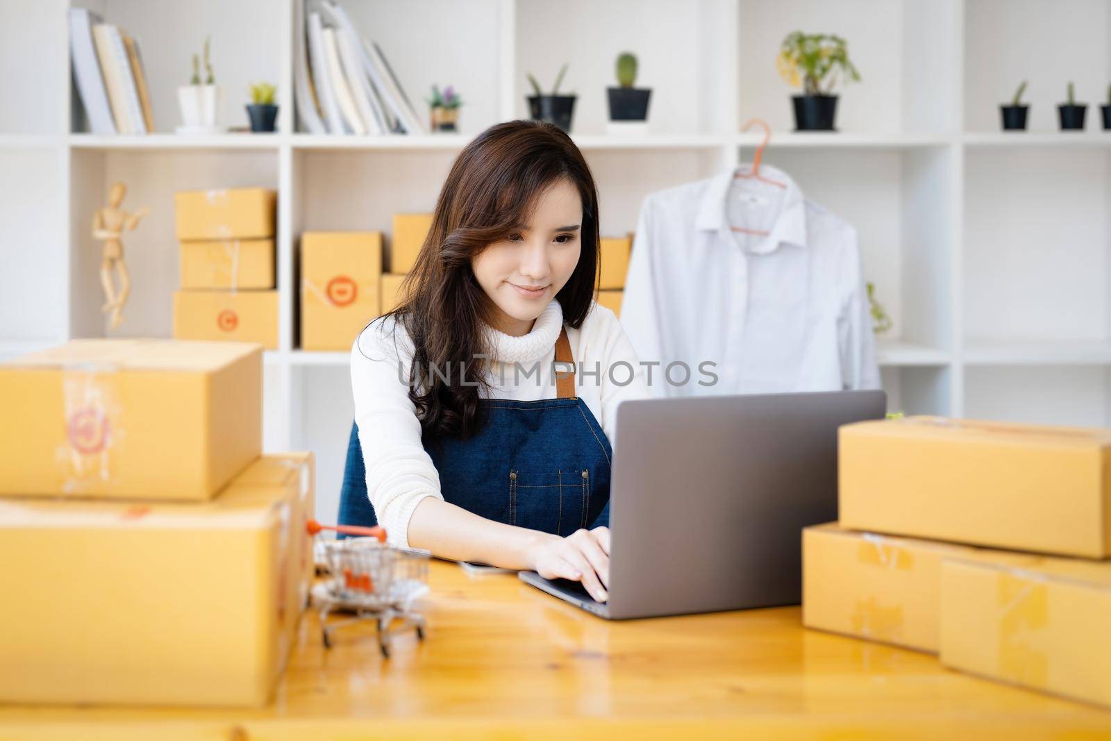 Work from home. happy women selling products online Start a small business owner by using laptop computer to calculate prices and prepare for postage