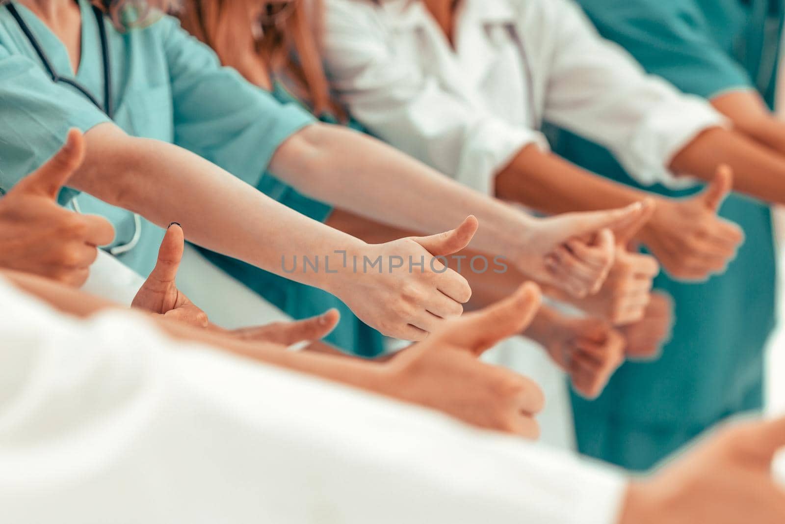 close up. group of doctors showing thumbs up. success concept
