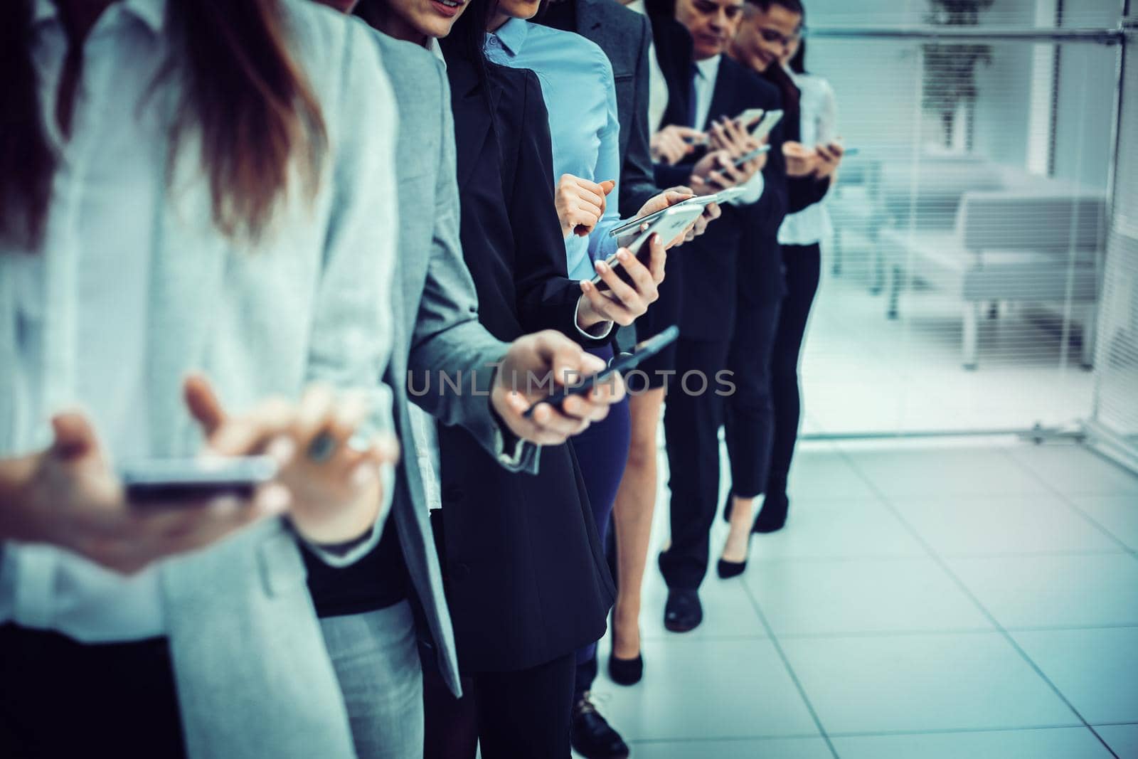 close up. a group of young business people looking at their smartphone screens