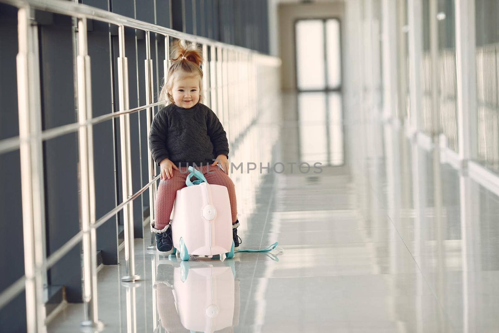 Child at the airport. Little girl with a suitcase.