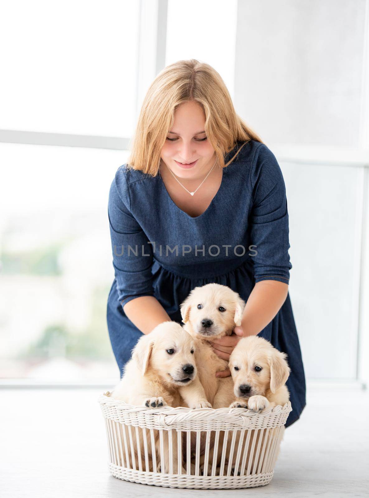 Smiling girl with puppies in basket