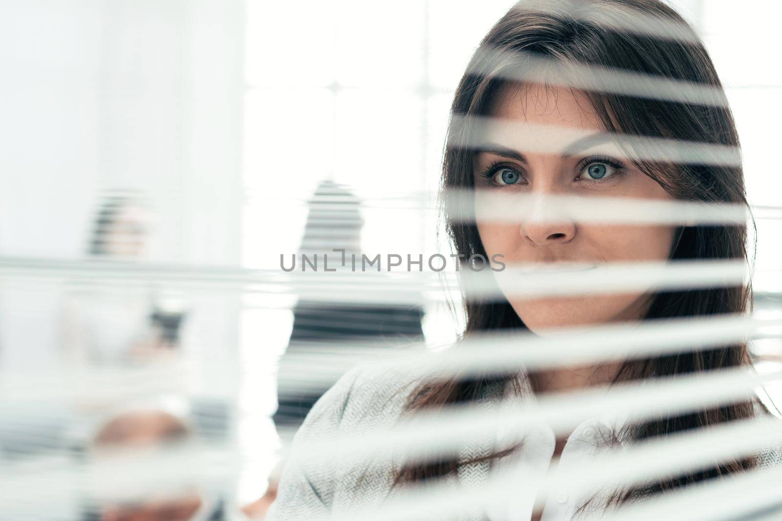 close up. young business woman looking through office window