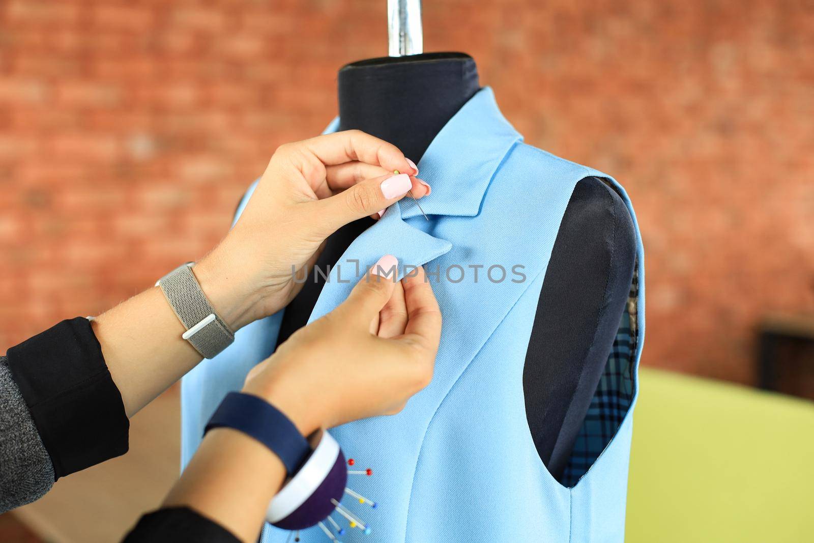 Young fashion designer working in her atelier on new cloths. by tsyhun