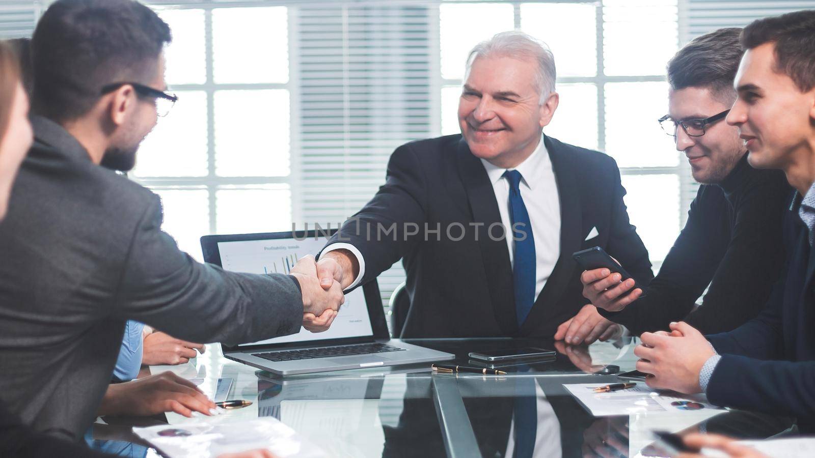 business partners shaking hands during a working meeting by SmartPhotoLab