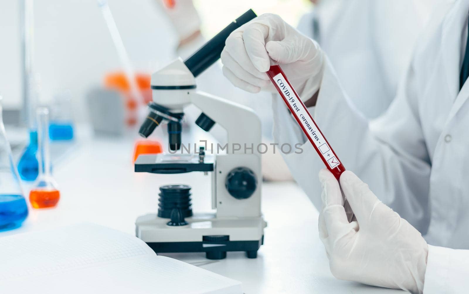 close up. scientist reading the inscription on the tube with the test. photo with a copy-space.