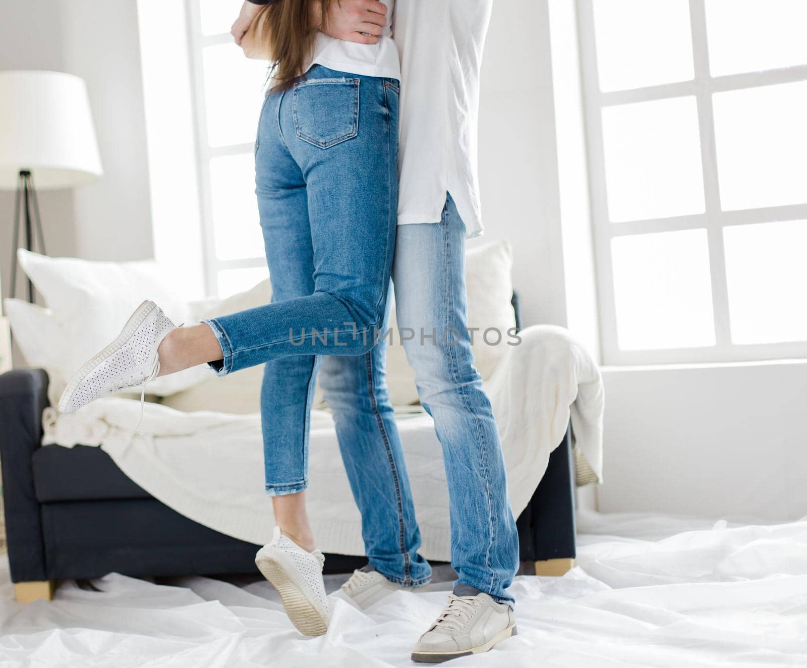 husband and wife hug standing in their new apartment. photo with copy-space