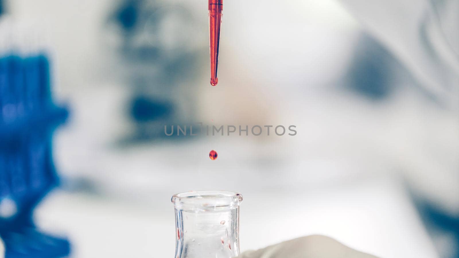 close up. background image of a drop of red liquid in a laboratory pipette. photo with a copy-space.